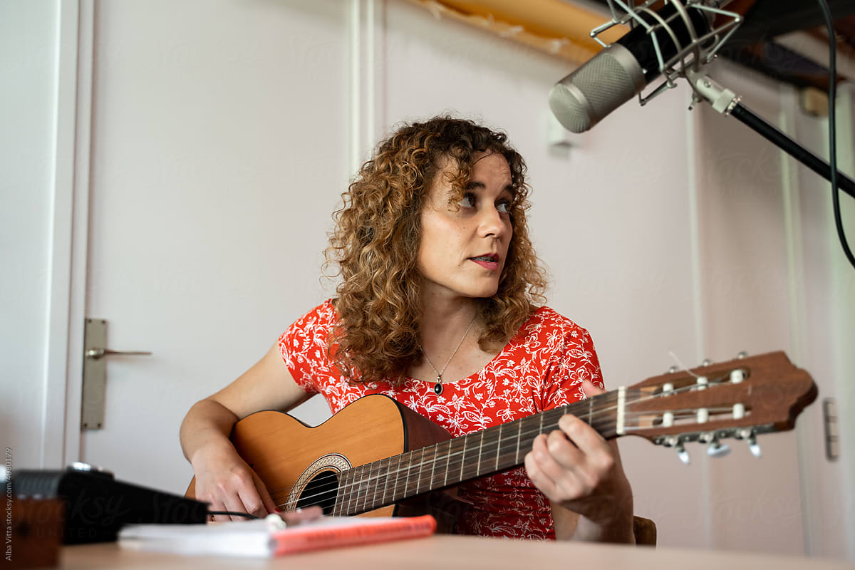 Woman playing and recording music at home studio