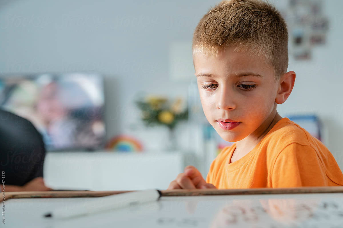 child writing on a whiteboard at home