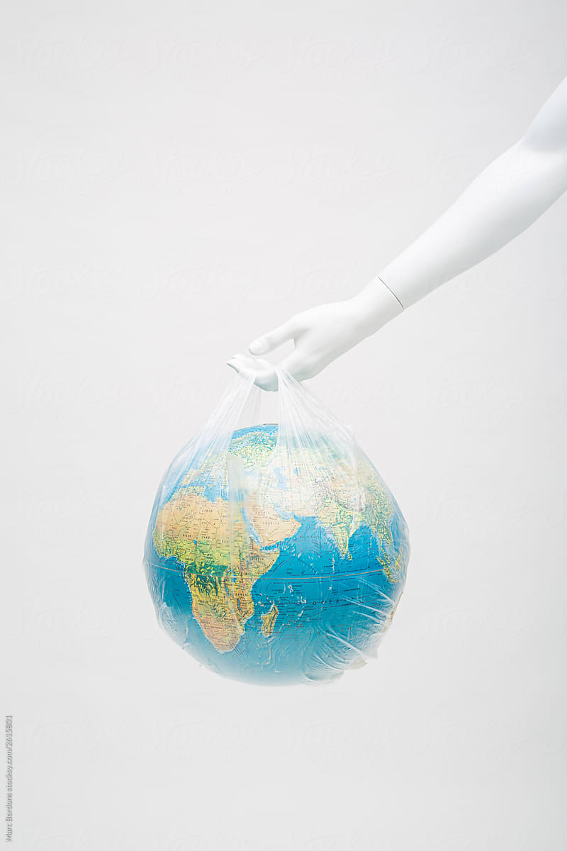 white mannequin\'s hand holding a globe in a plastic bag