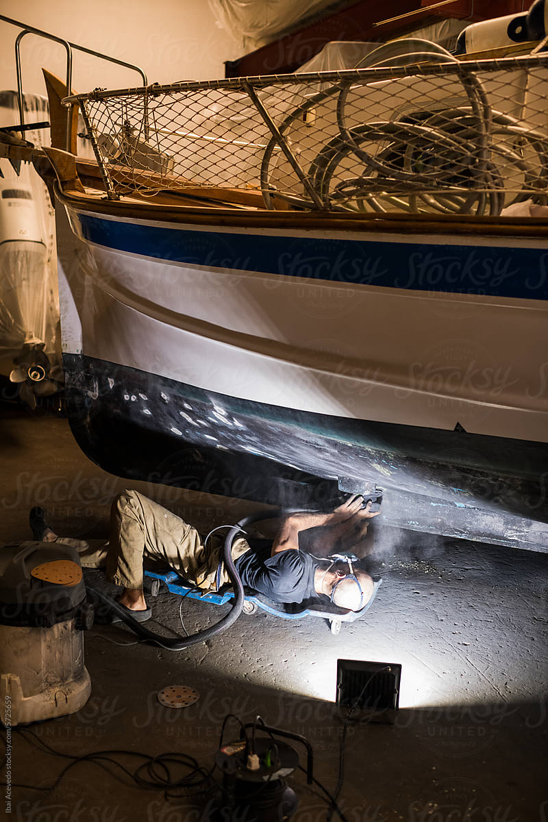 Skilled repairman restoring boat hull at workshop