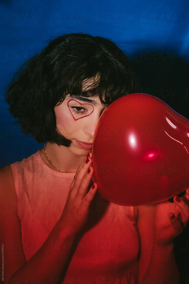 Portrait of a girl Holding a Red Balloon Indoors