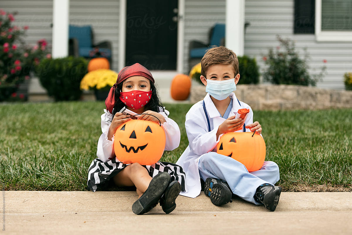 Halloween: Kids Sit On Curb With Candy Buckets