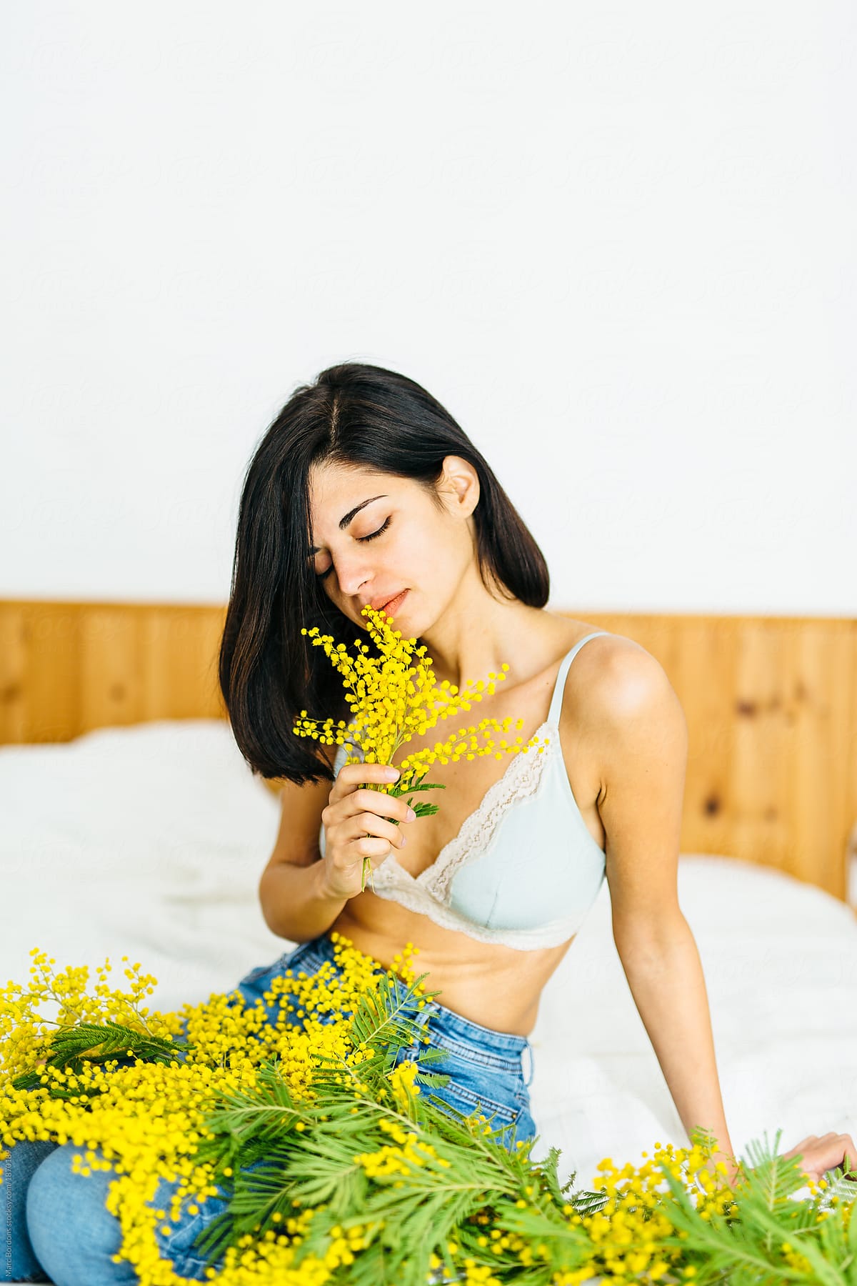 brunette girl with mimosa plants in her hands