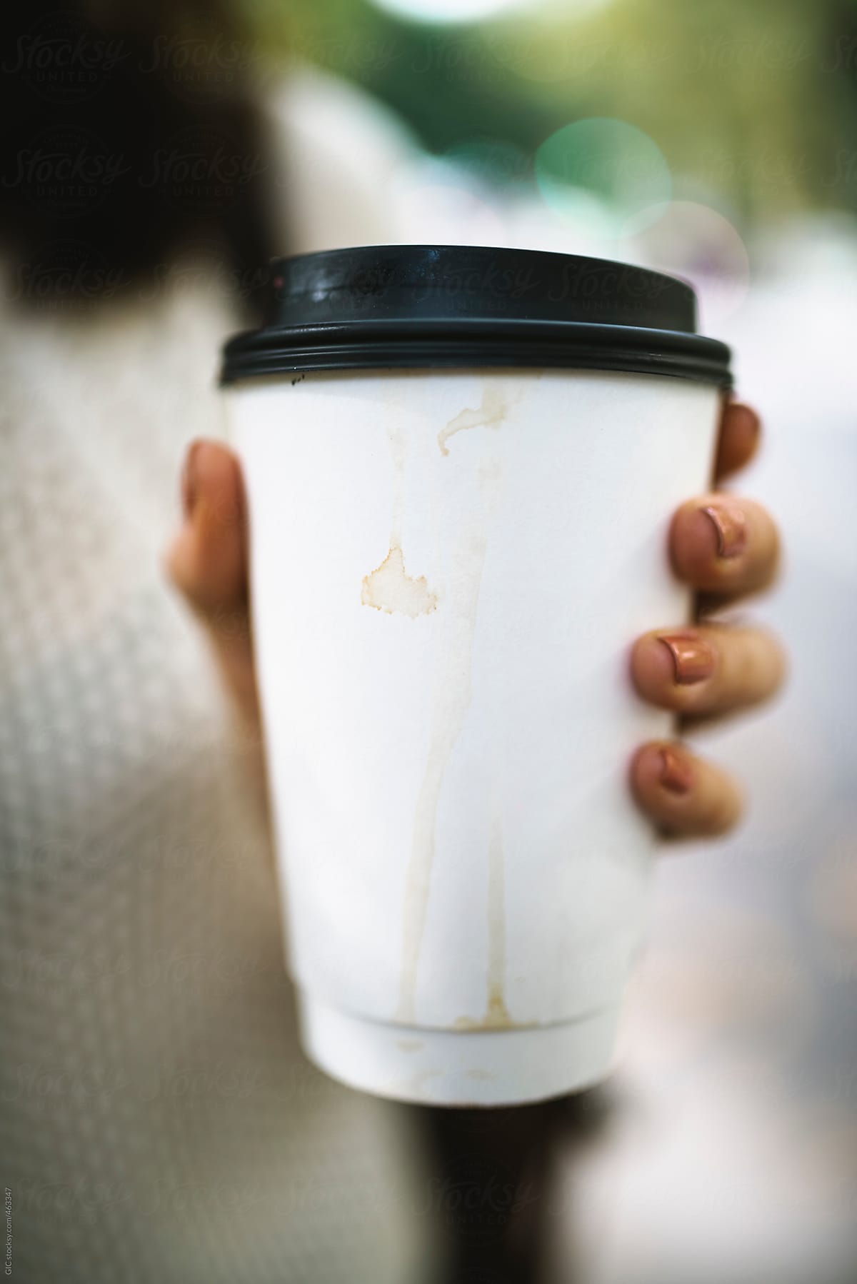 Hand holding a stained coffee cup