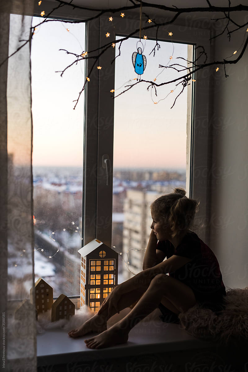 Girl on the windowsill with her favourite toy