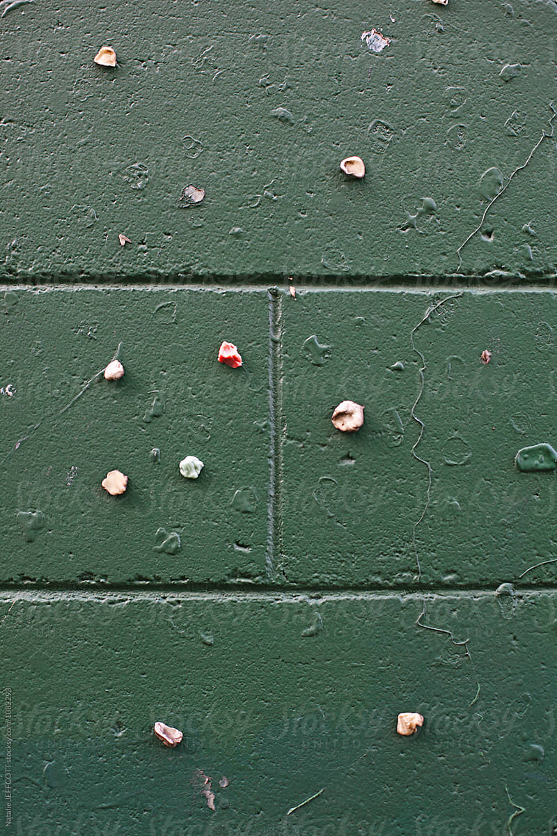 Green cement block wall with colourful chewing gum