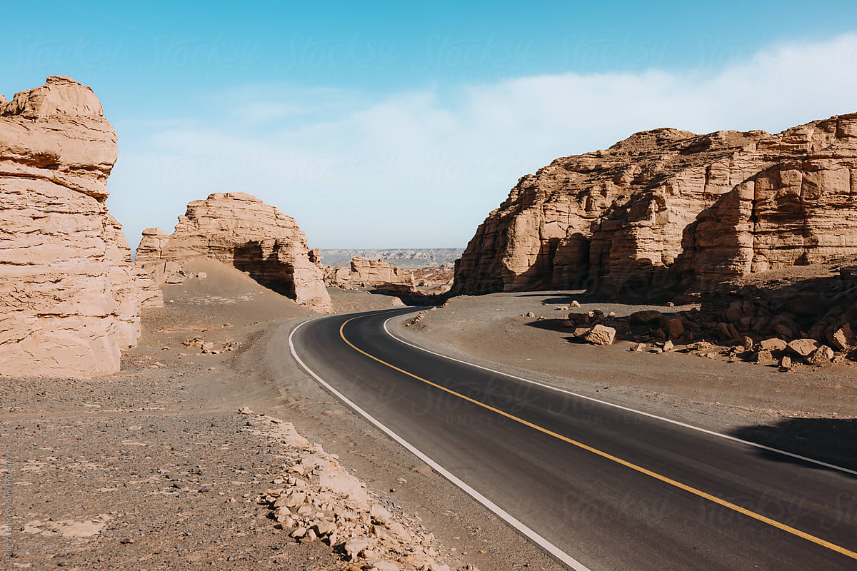 Curved Desert Road Through Rock Formations