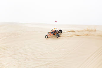 Young Man Jumping A Dirt Bike On The Sand Dunes | Stocksy United