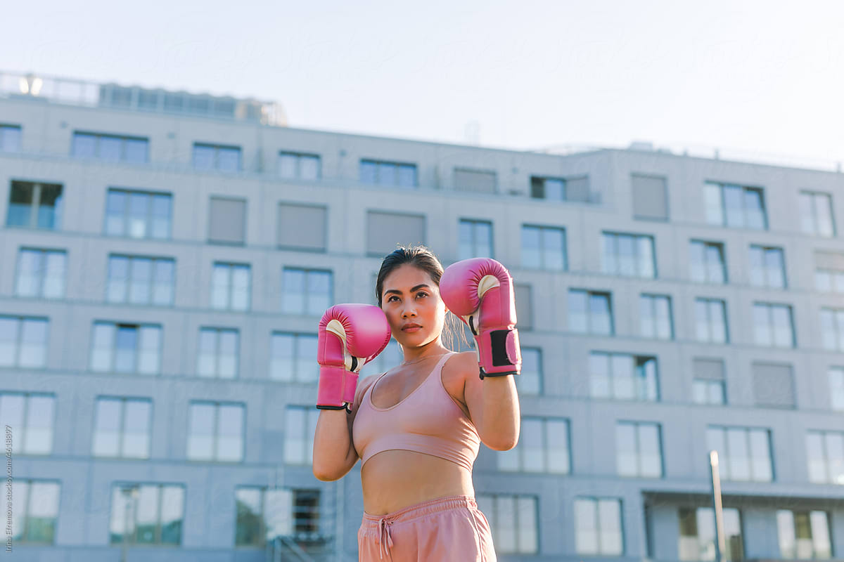 Woman in a pastel pink outfit shadow boxing outside