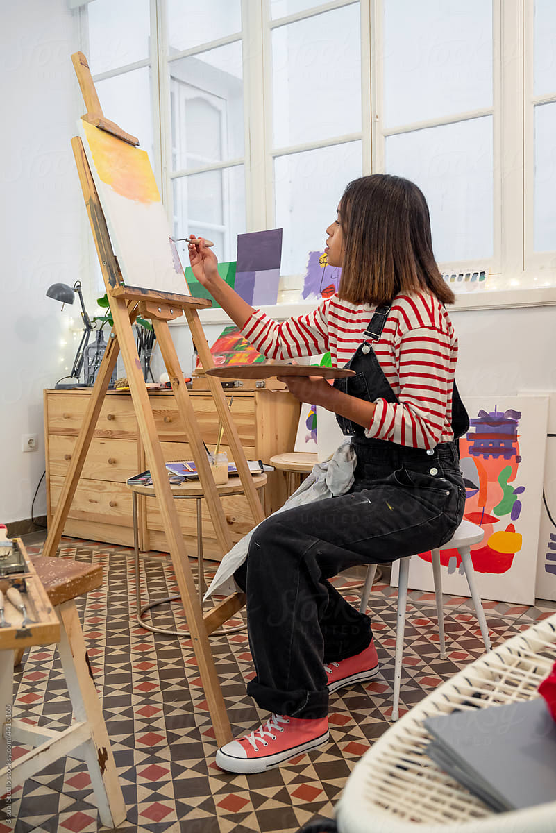 Black woman painting in art studio