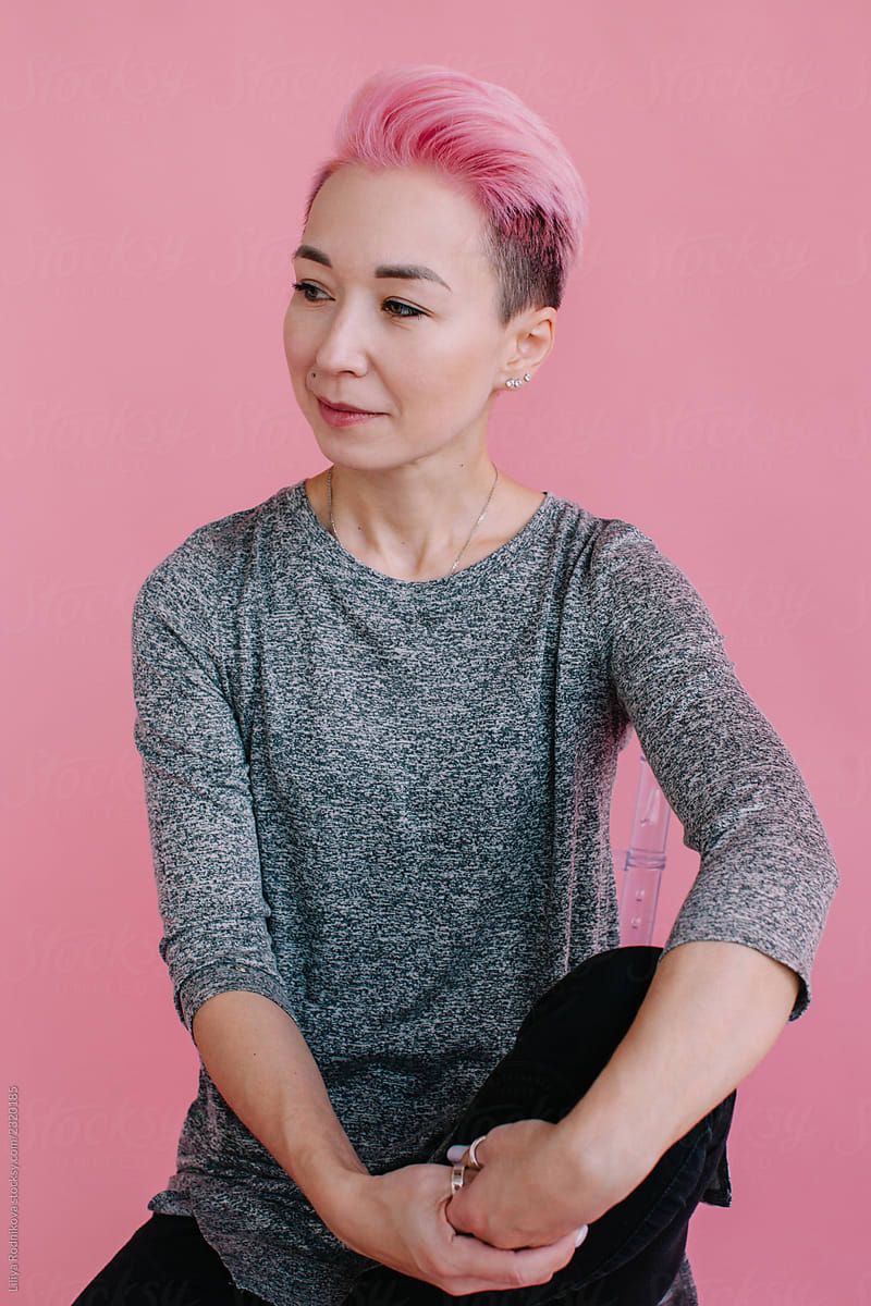 Studio portrait of woman with pink short hair