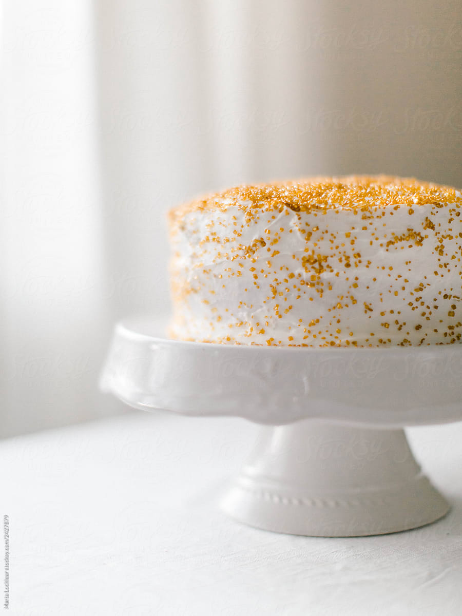 Gold Sprinkle Cake On A White Cake Stand by Stocksy Contributor Marta  Locklear - Stocksy