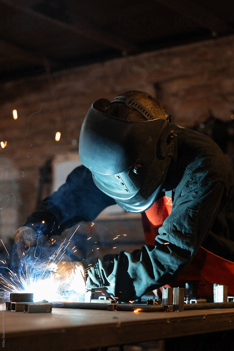 Male metalworker welding metal parts