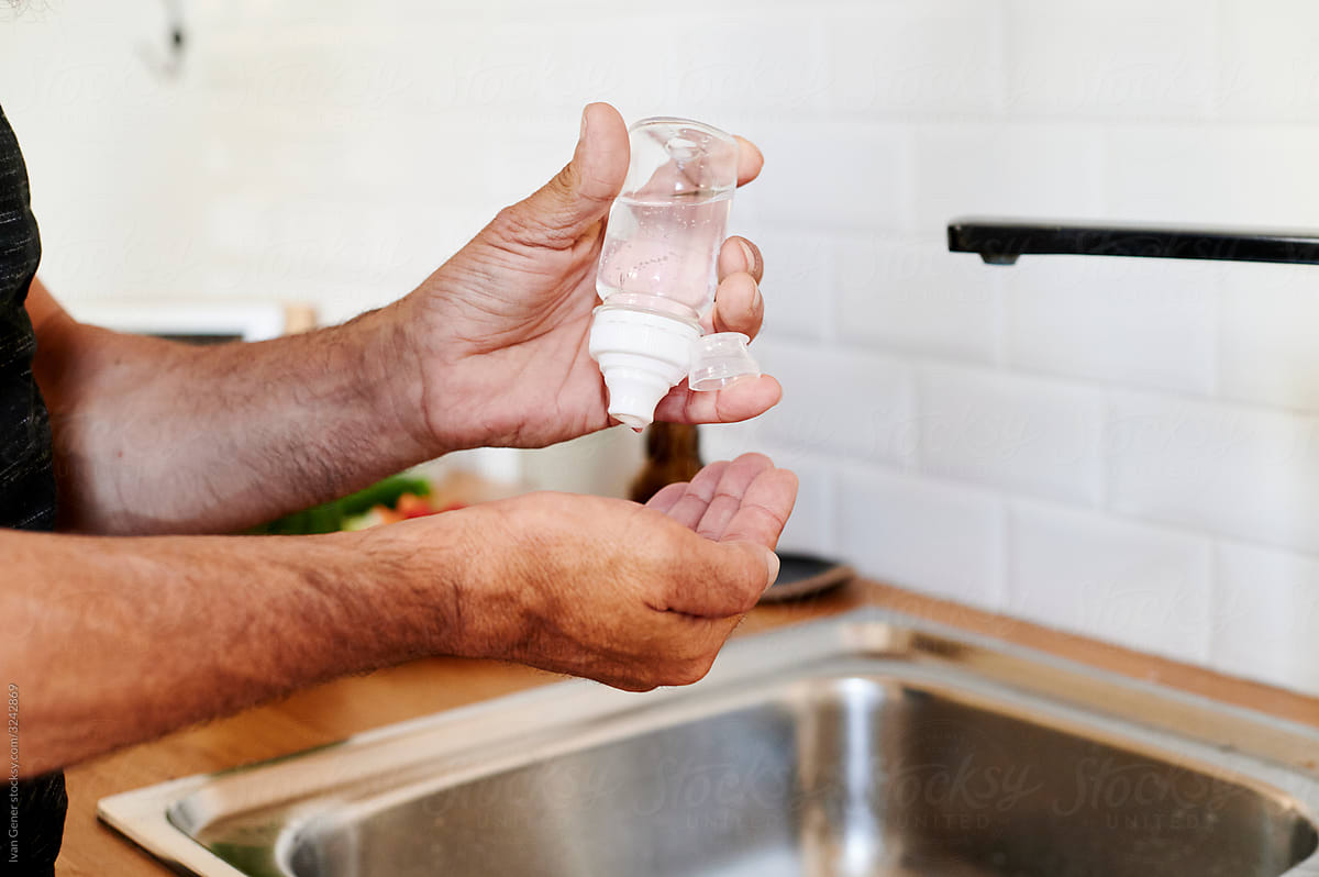 Man applying hand sanitizer at home