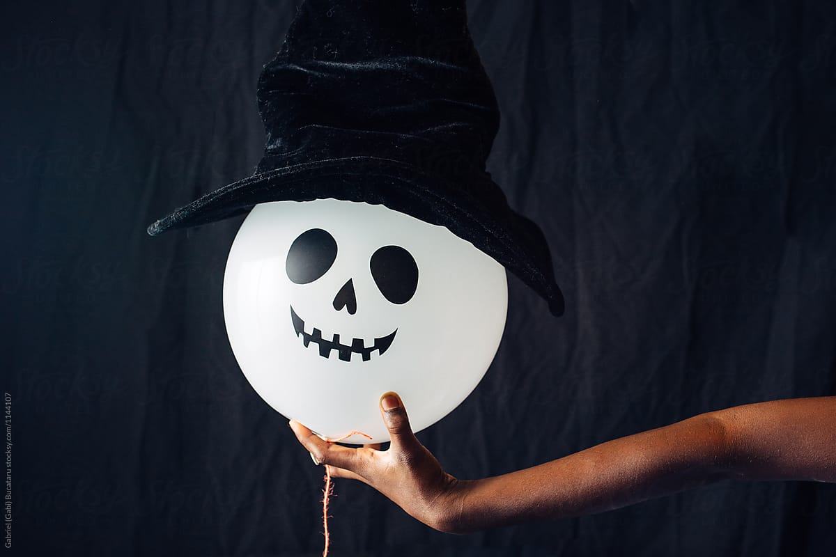 Silly Halloween balloon with wich hat in child\'s hand