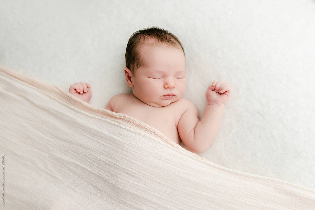Newborn laying on a white blanket