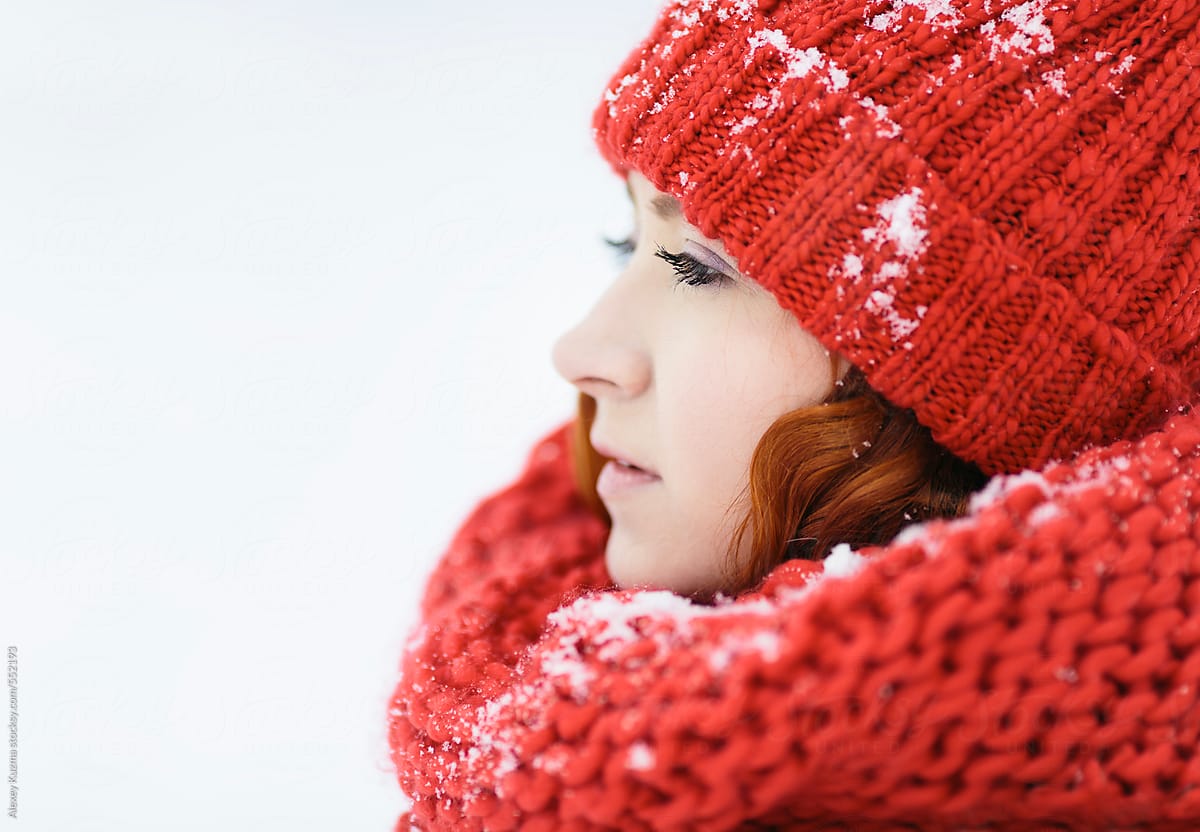 winter portrait of the young woman with red hat and scarf