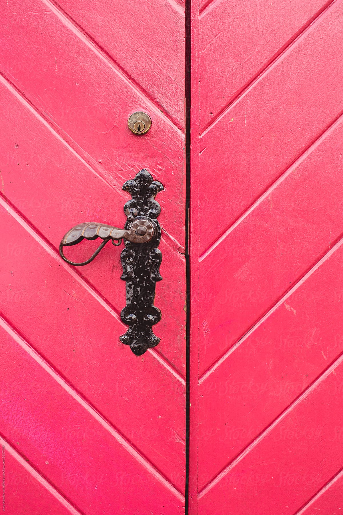 Vibrant antique red door with cast iron handle