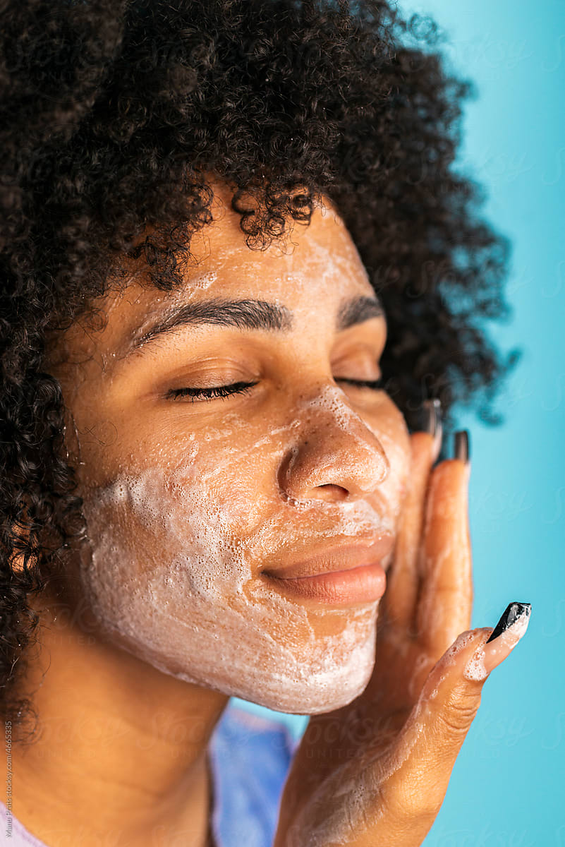 Brown skinned woman cleansing face with handmade soap