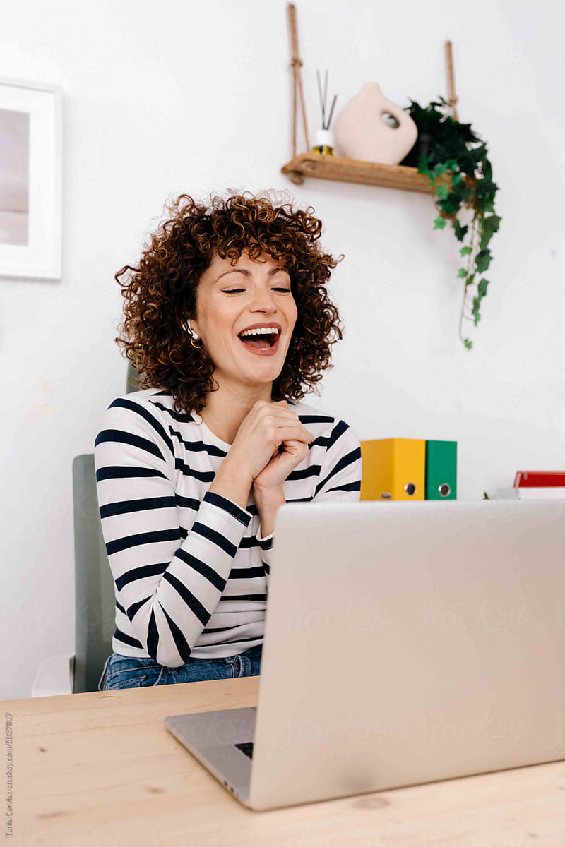 Cheerful woman with laptop in office
