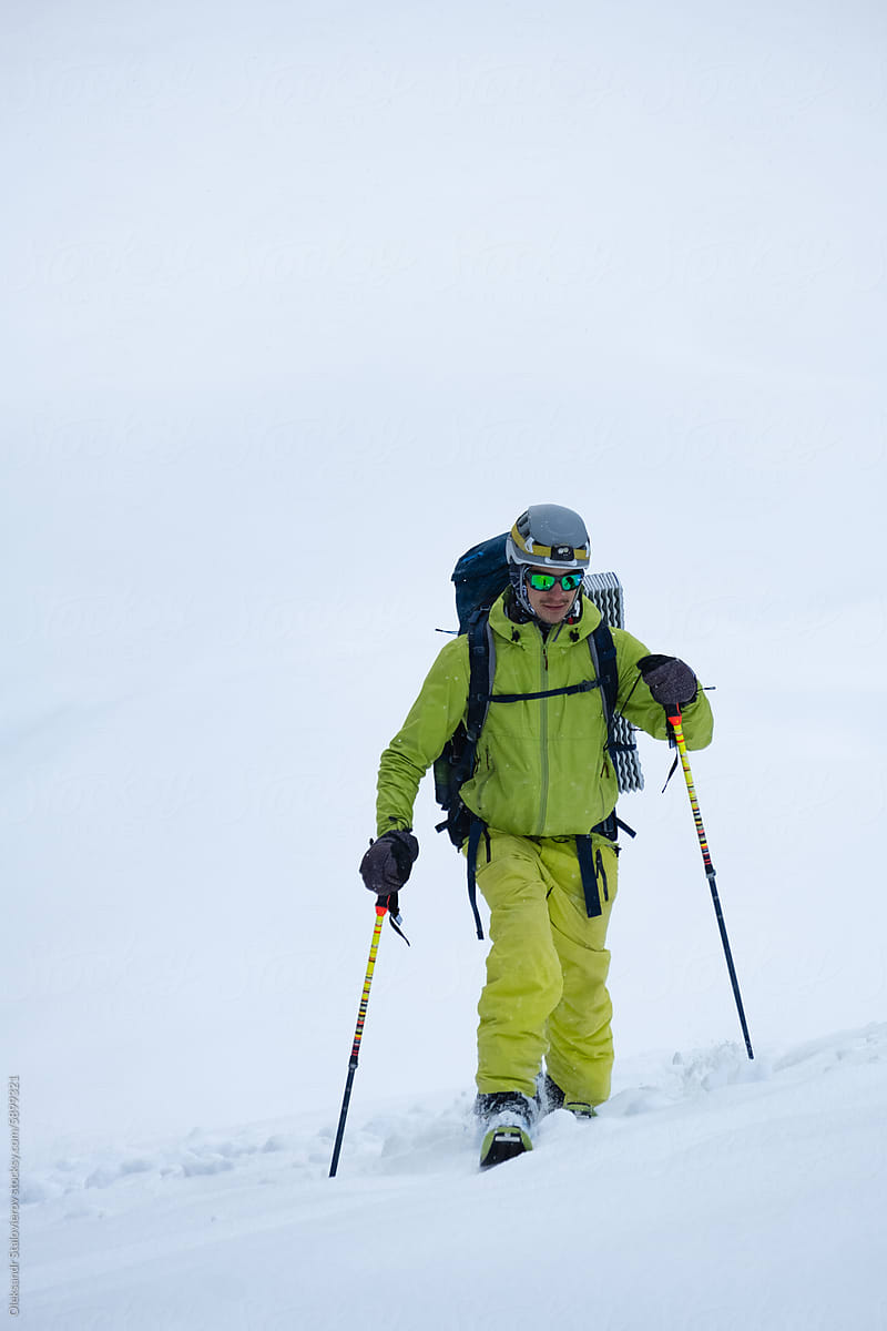 A man ski touring near old vintage house with deep snow.