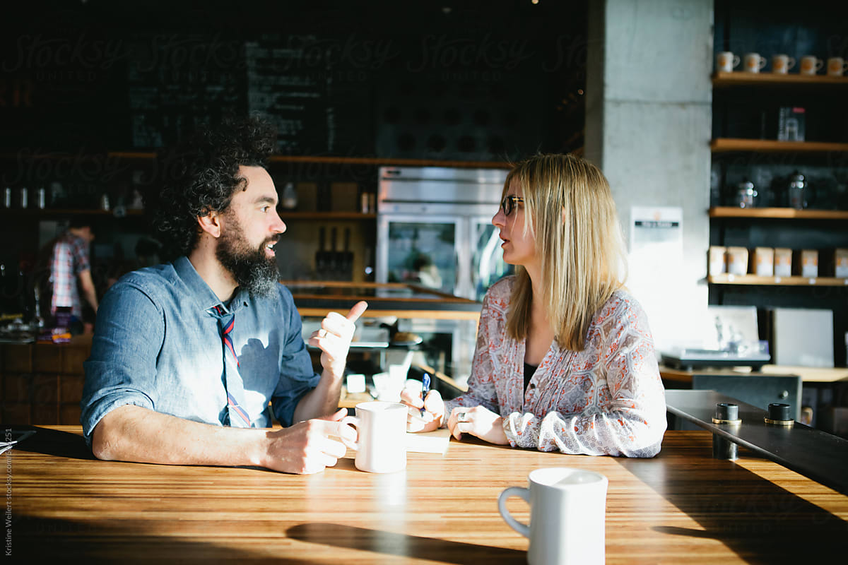 Man and woman having a conversation over coffee in a cafe