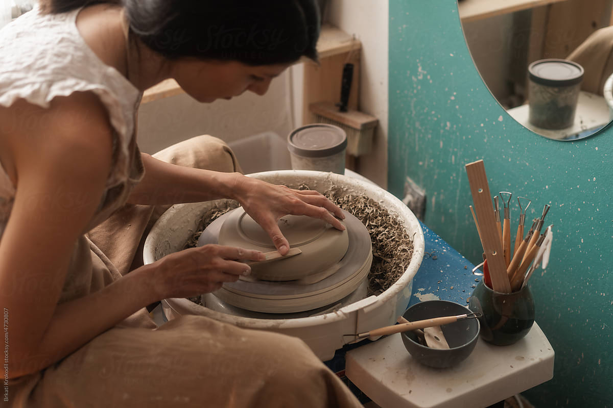 Female Potter Working On The Piece Of Clay Bowl On The Wheel
