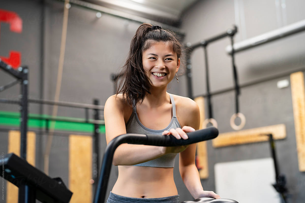 Asian sportswoman exercising on machine