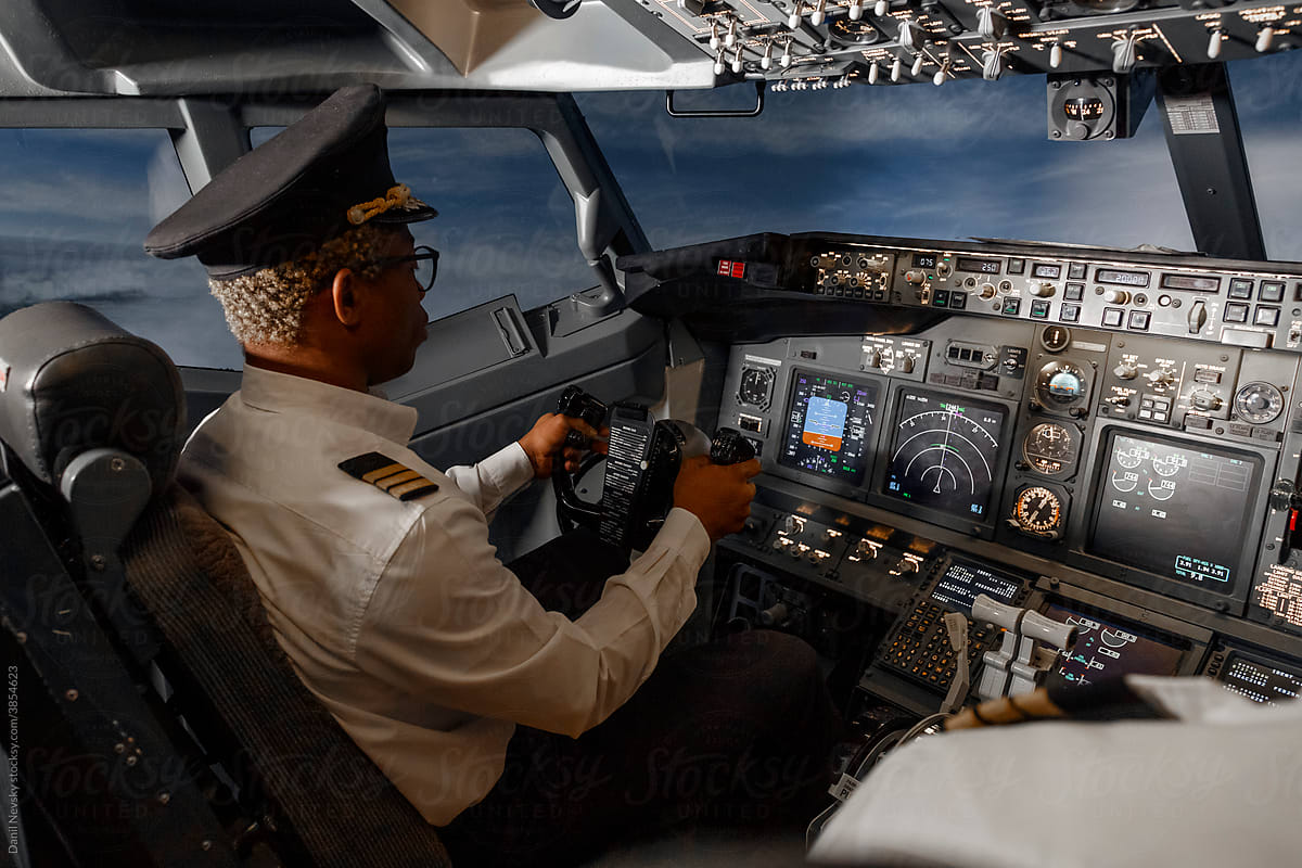 Black pilot steering plane in cloudy sky