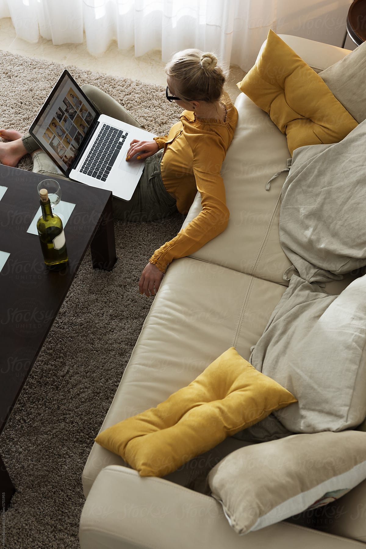 Woman lounging with laptop having wine
