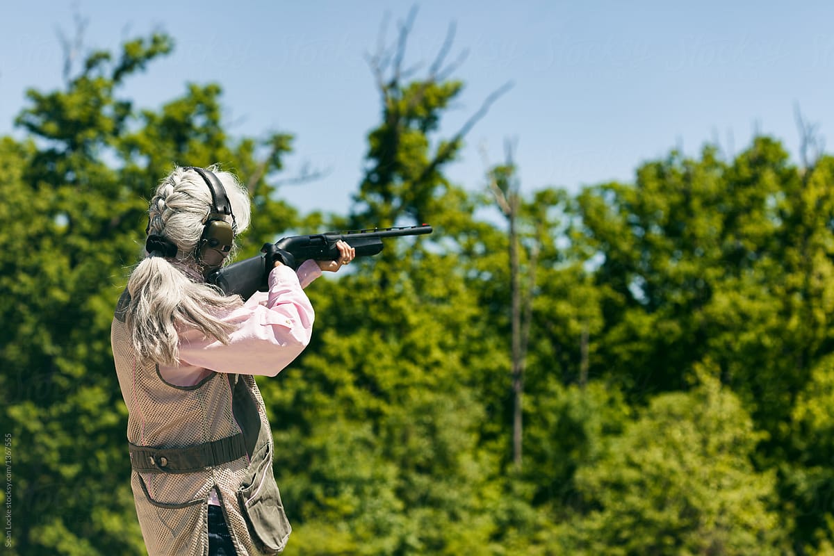 Shooting: Woman Aiming Shotgun Wearing Ear And Eye Protection
