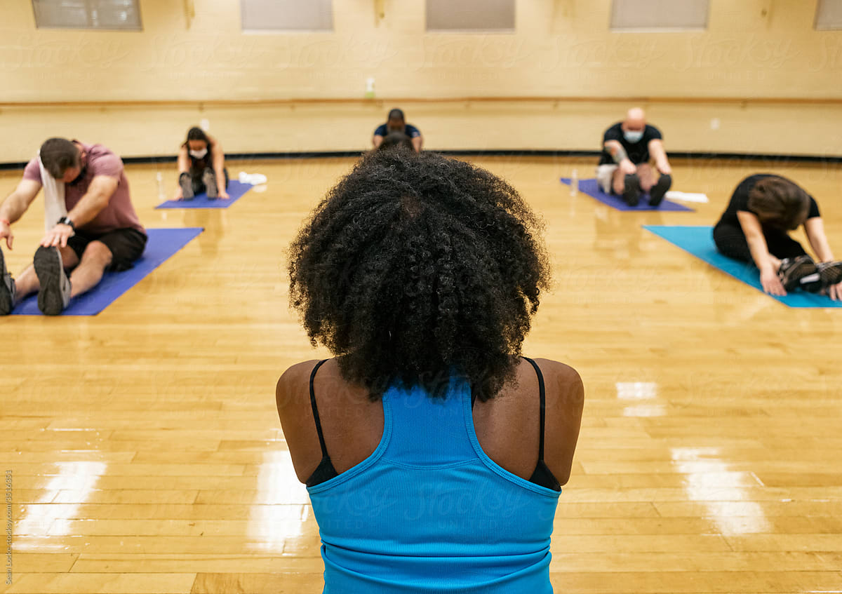 Gym: Group Wearing Face Masks Participates In Stretch Class