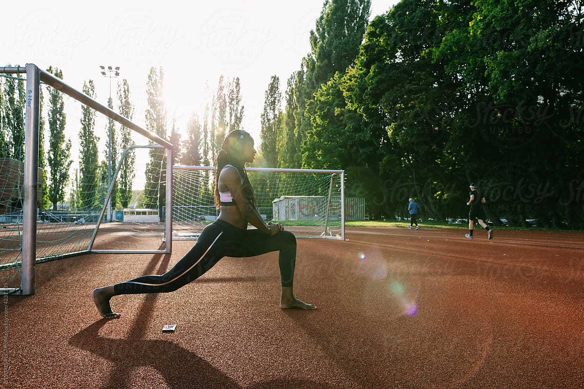 Female African Athlete Stretching in Warm Afternoon Sunlight