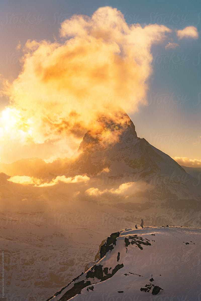 Matterhorn Mountain during the sunset with a tiny figure of a person in front