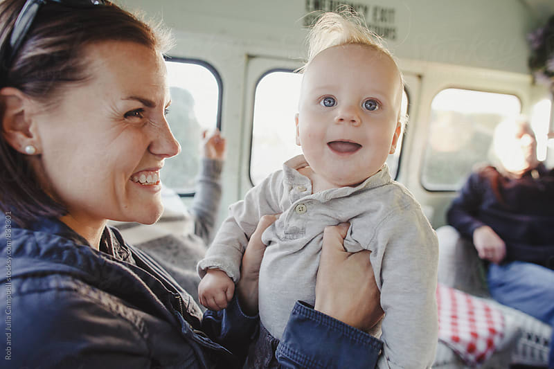 Mom playing with baby boy in old school bus