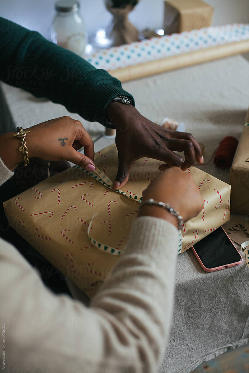 Black couple wrapping presents for Christmas
