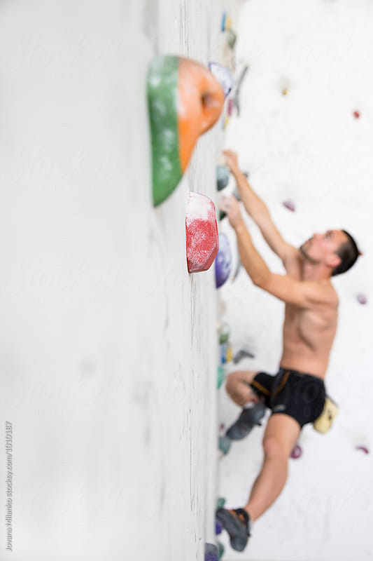 Free climber exercising on an indoor climbing wall