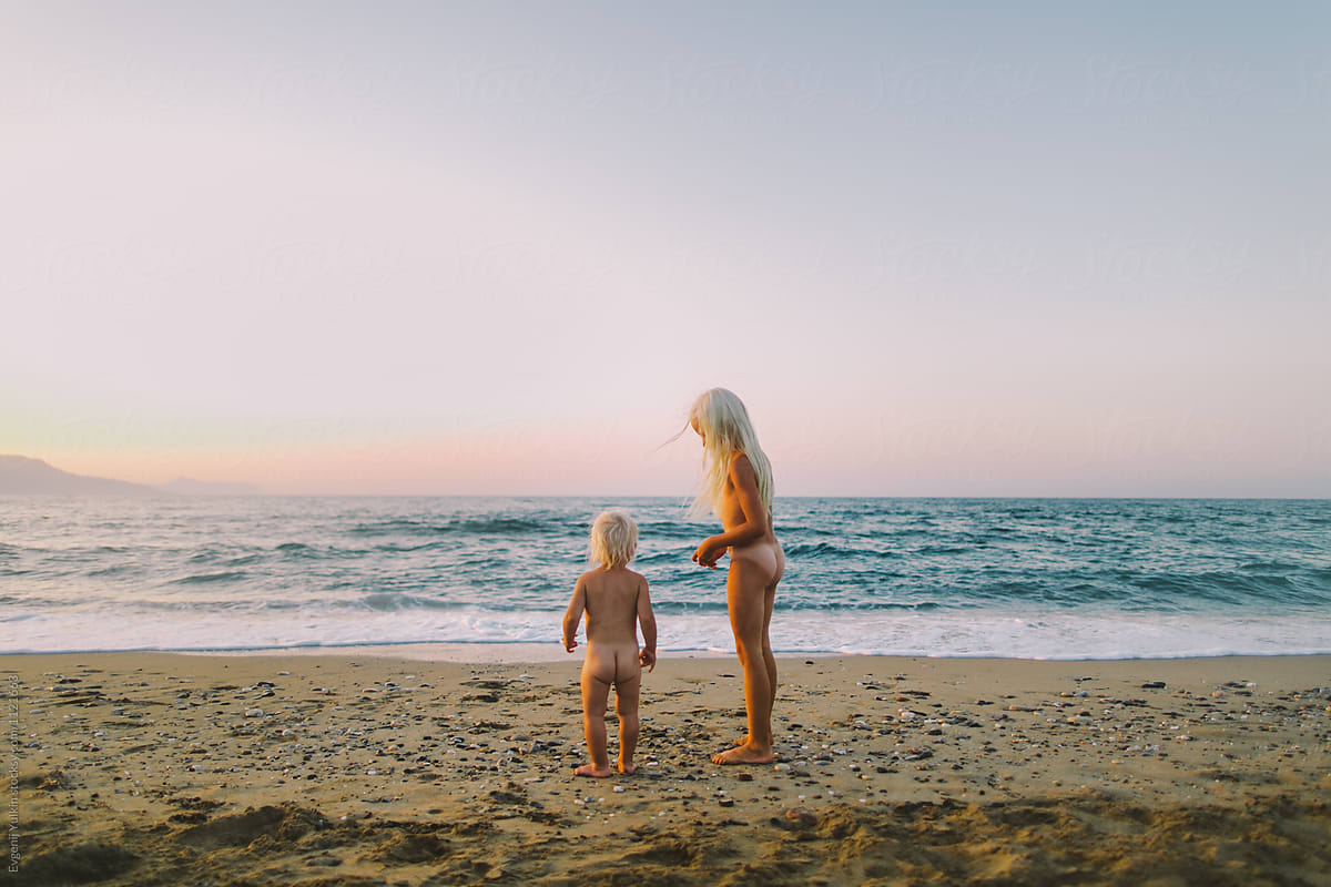 Two Little Naked Sisters On The Beach At Sunset porEvgenij Yulkin.