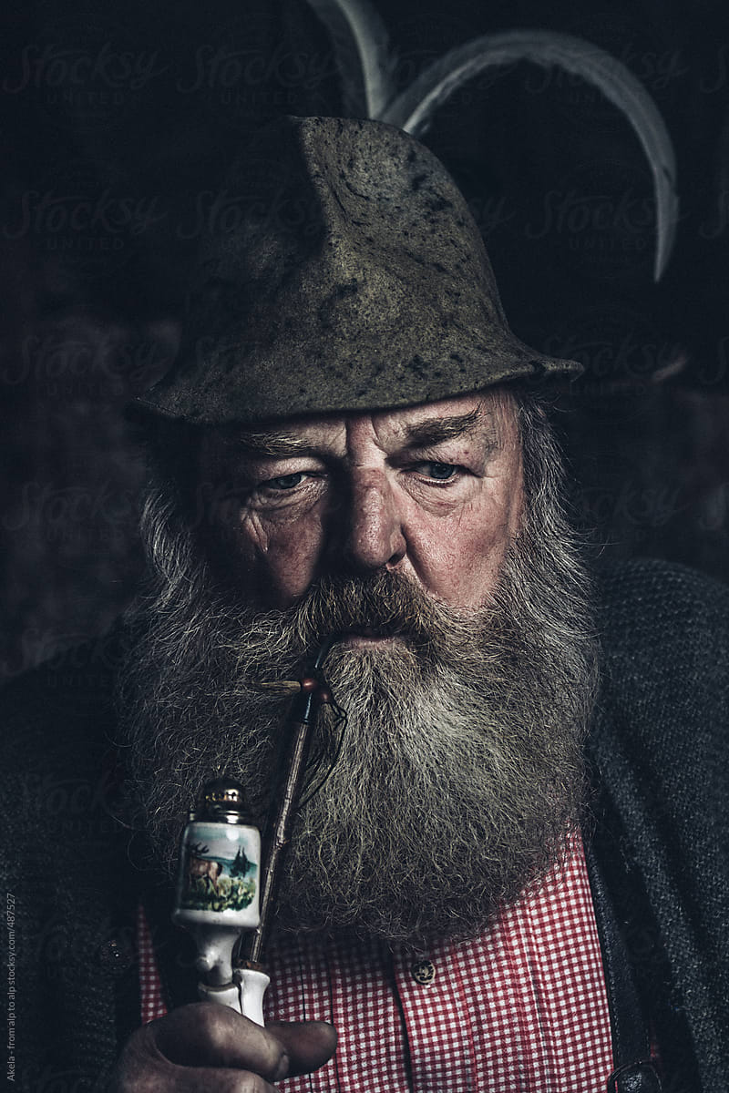 portrait of full bearded old man with a pipe and a millinery