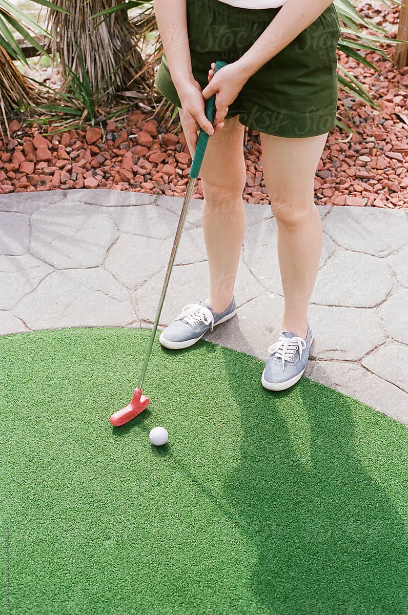 Woman Plays Miniature Golf