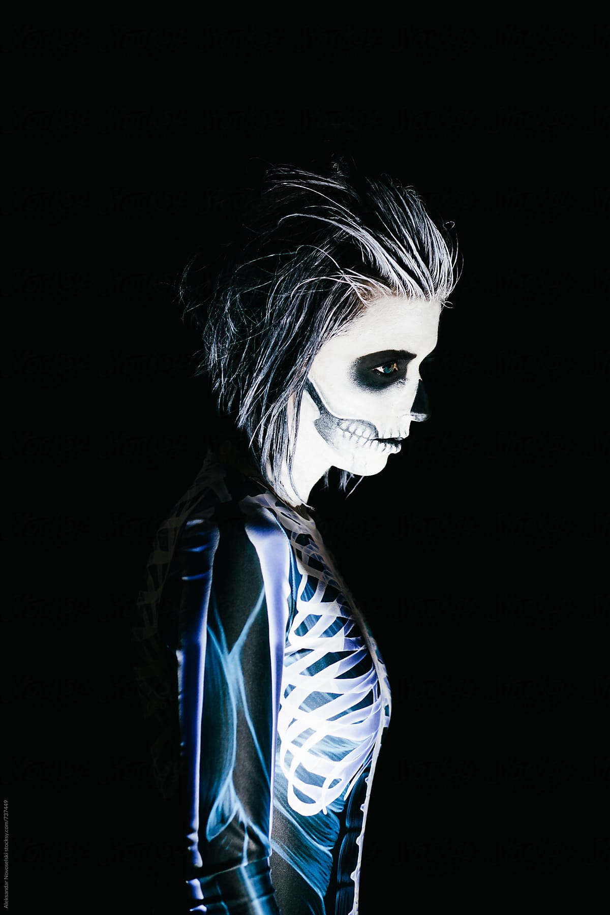 Woman with skeleton costume and halloween make up on black