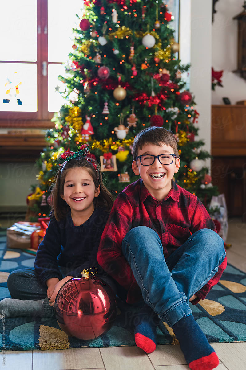 Happy Siblings Portrait with Christmas Tree