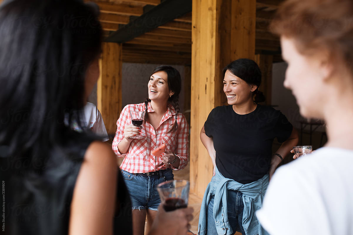 Happy women chatting during wine tasting in cellar