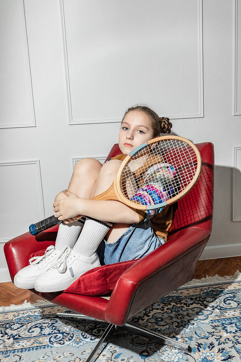 portrait of a thoughtful teenage girl with a tennis racket
