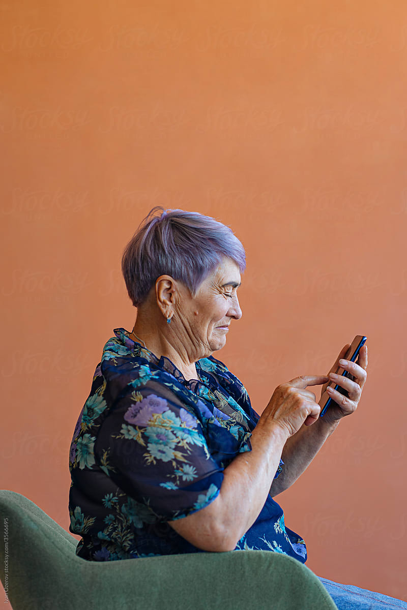 happy elderly woman texting on smartphone