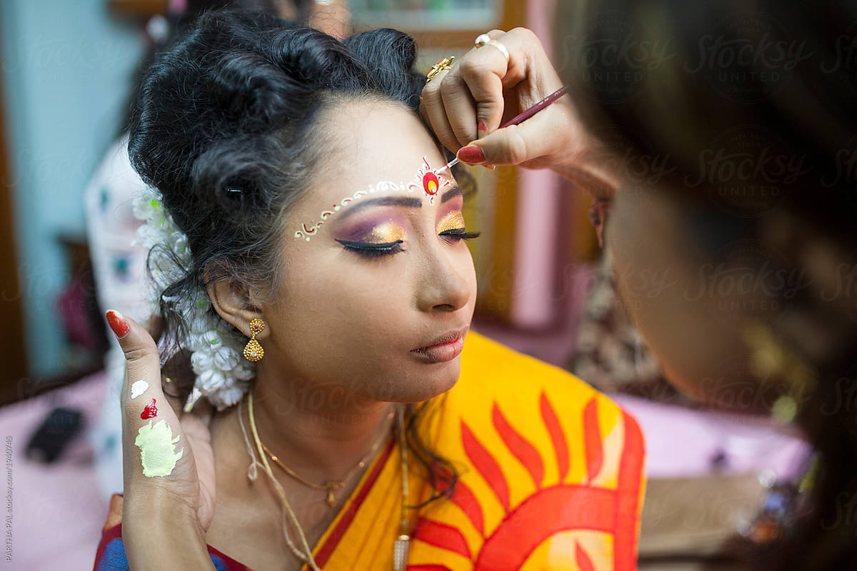 A girl doing make up in a wedding ceremony