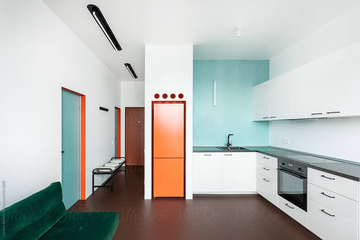 Minimalist living / kitchen with a empty countertop and orange fridge