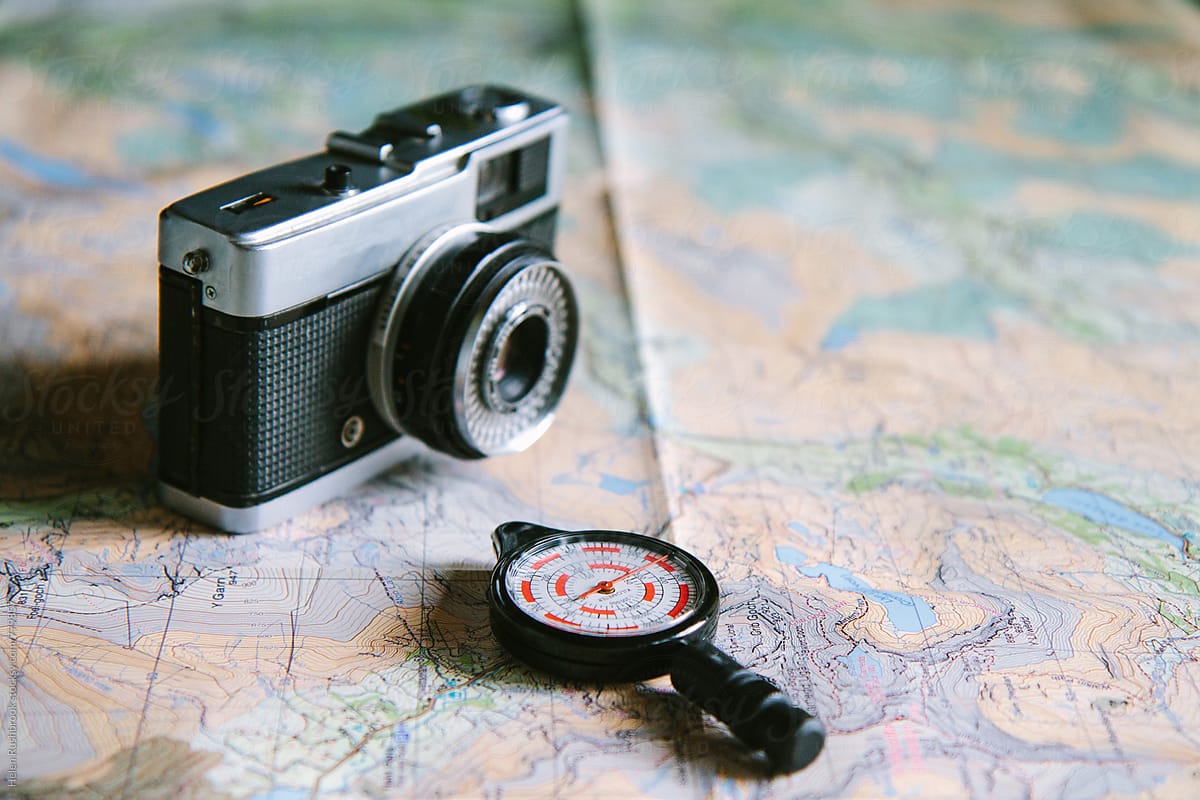 Vintage camera and opisometer on a map.