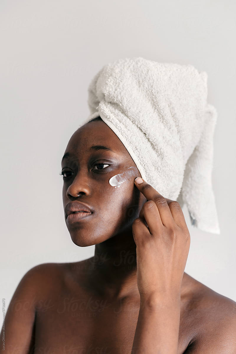 Black woman using skincare lotion