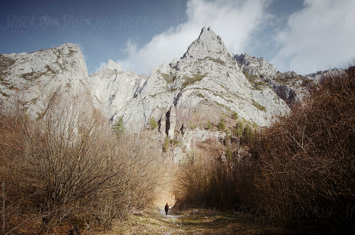 Fantasy mountain landscape with man walking on path